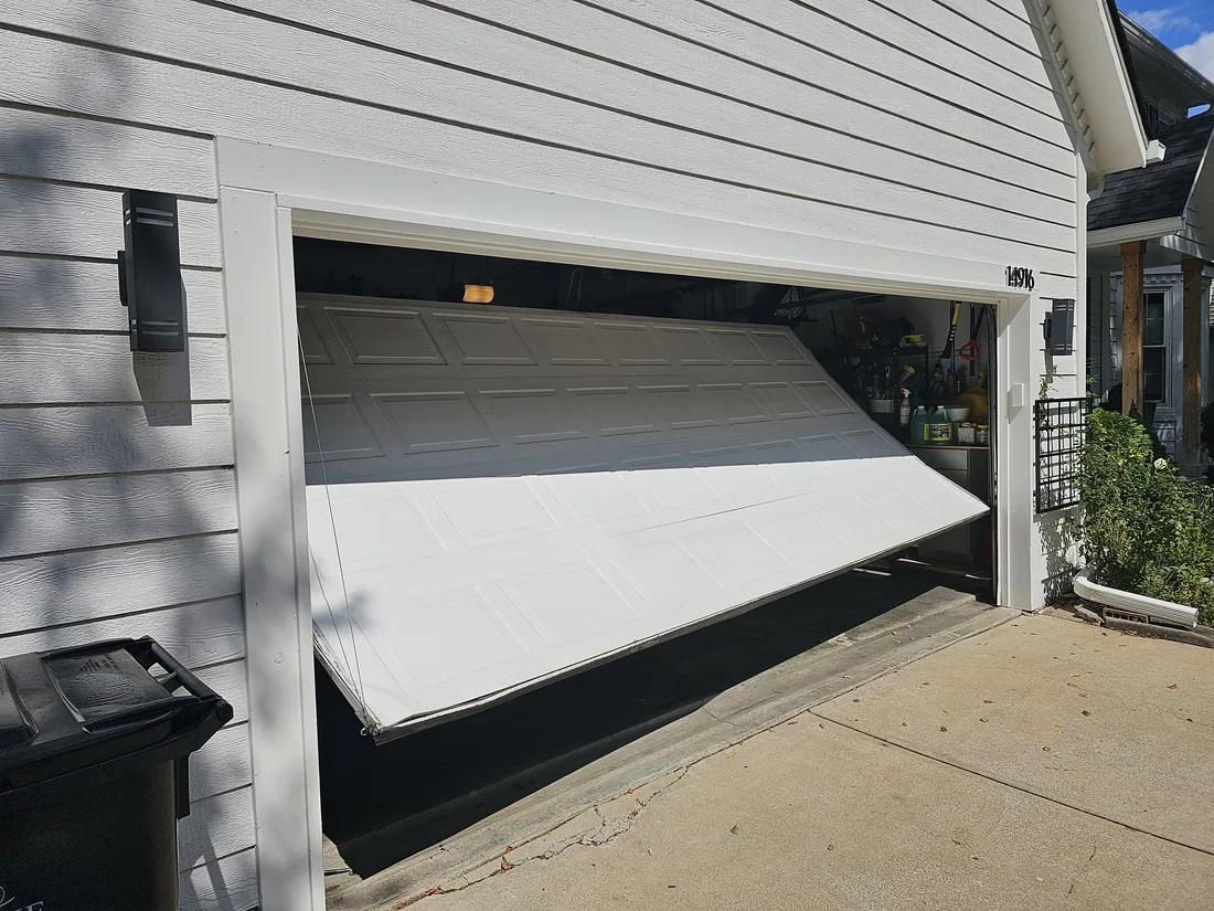 Off-track garage door repair — realigning a sectional door panel after impact in Kansas City