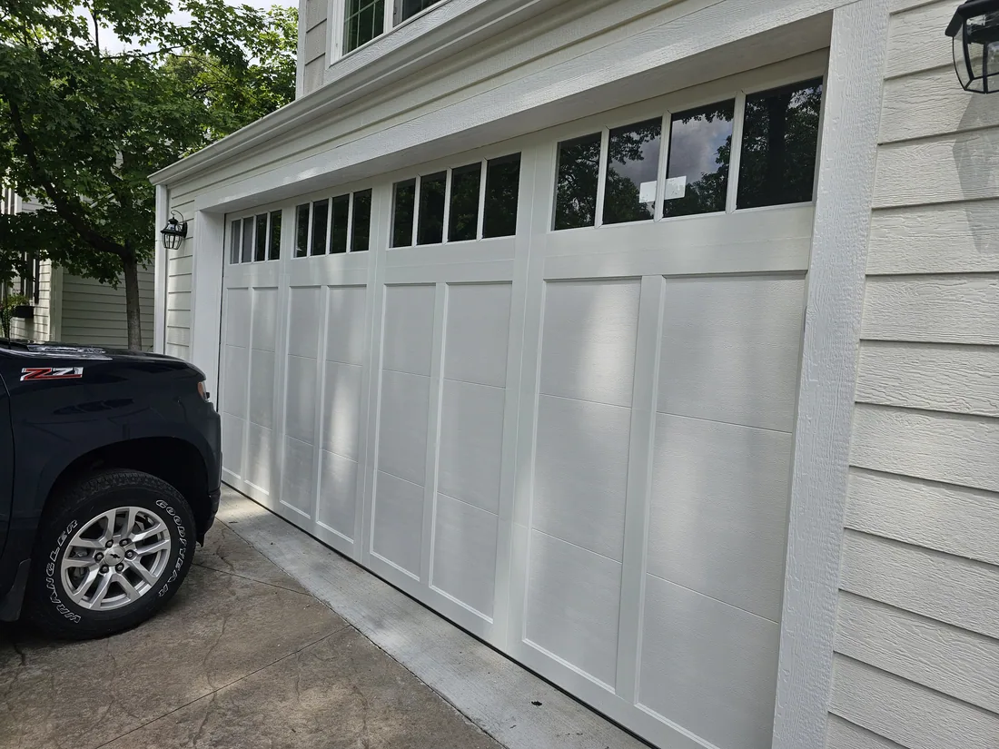 Finished garage door replacement on a Kansas City metro residential home — new sectional door