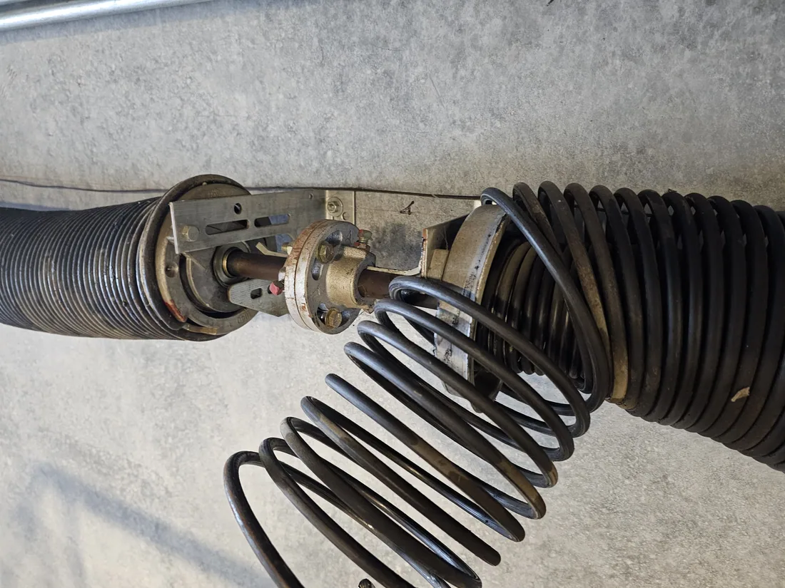 New garage door torsion spring being wound and tensioned by a GDM KC technician