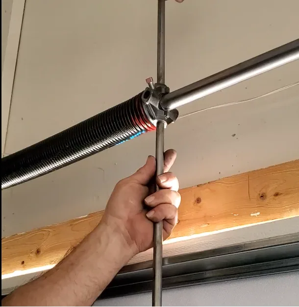 Close-up of a garage door torsion spring and winding cone before replacement in Kansas City