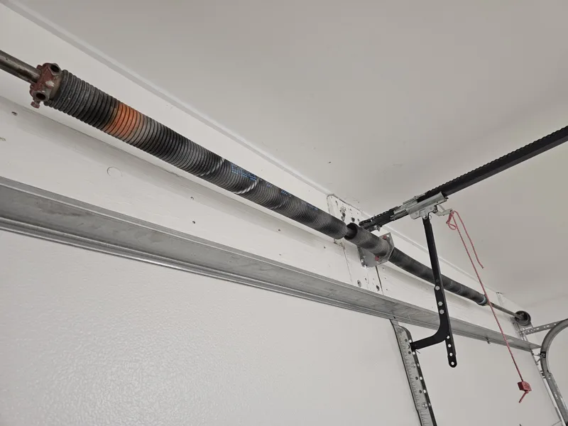 Pair of new torsion springs installed on a garage door header by GDMKC